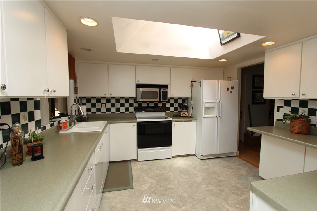 320 170th Place Southwest Bothell, WA 98012 - Photo 6 of 25 a kitchen with a refrigerator and a sink