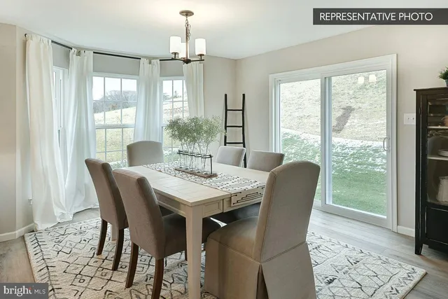 a dining room with furniture a chandelier and wooden floor