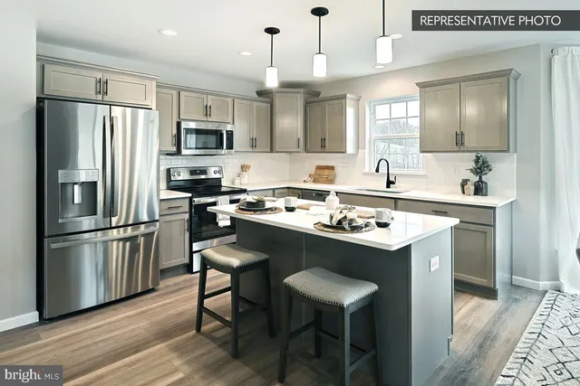 a kitchen with a sink a refrigerator a stove and chairs