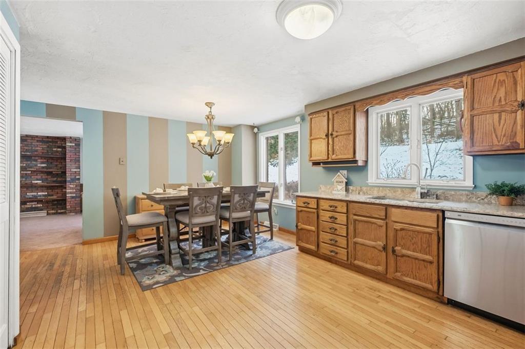 21 West Hillcrest Road Eighty Four, PA 15330 - Photo 21 of 45 a large open kitchen with stainless steel appliances granite countertop a stove a sink a dining table and chairs with wooden floor