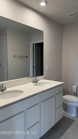 a bathroom with a granite countertop sink mirror and toilet