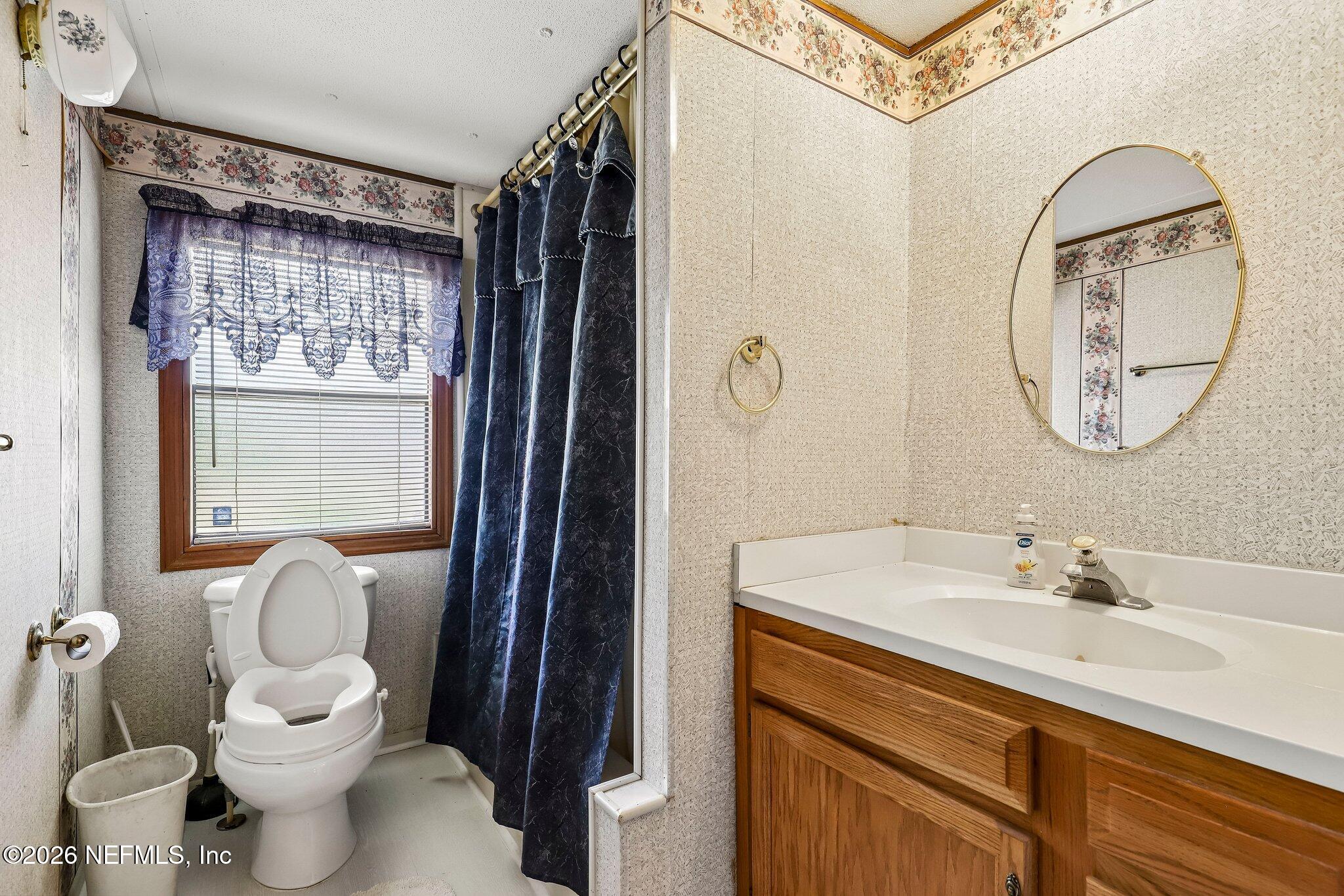 9690 Black Jack Road Macclenny, FL 32063 - Photo 14 of 34 a bathroom with a toilet sink and mirror