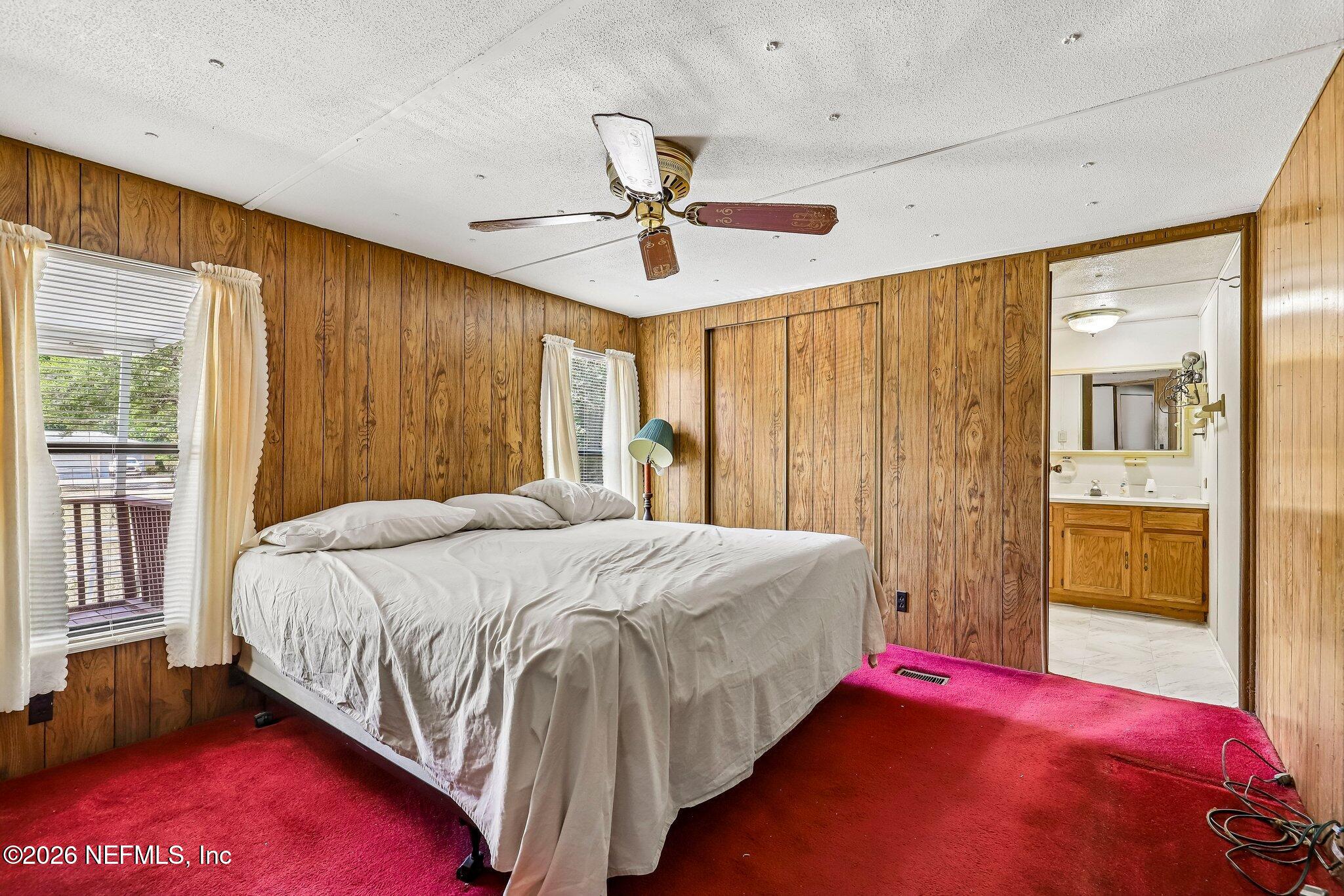 9690 Black Jack Road Macclenny, FL 32063 - Photo 20 of 34 a bedroom with a large bed and a chandelier
