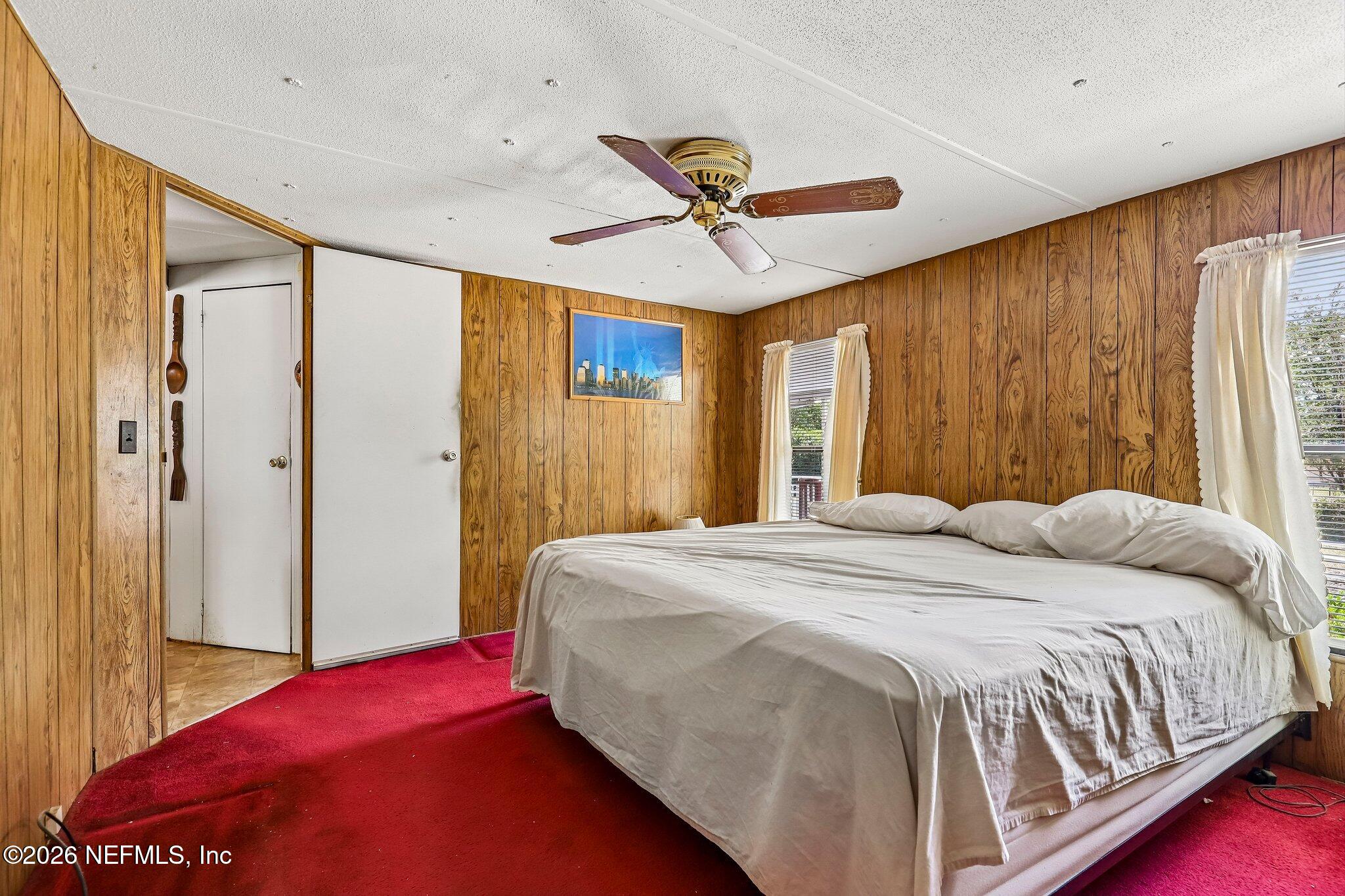 9690 Black Jack Road Macclenny, FL 32063 - Photo 21 of 34 a bedroom with a large bed and a chandelier
