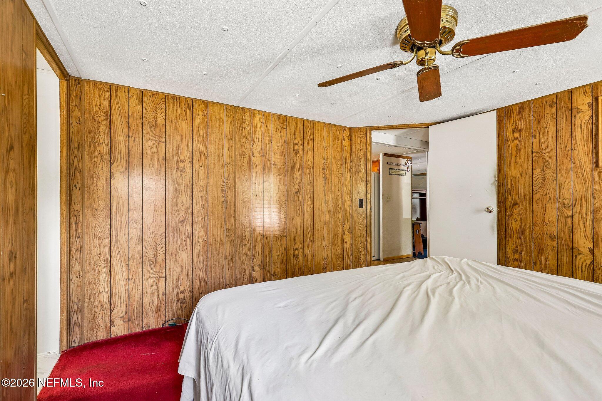 9690 Black Jack Road Macclenny, FL 32063 - Photo 22 of 34 a bedroom with a bed and a chandelier
