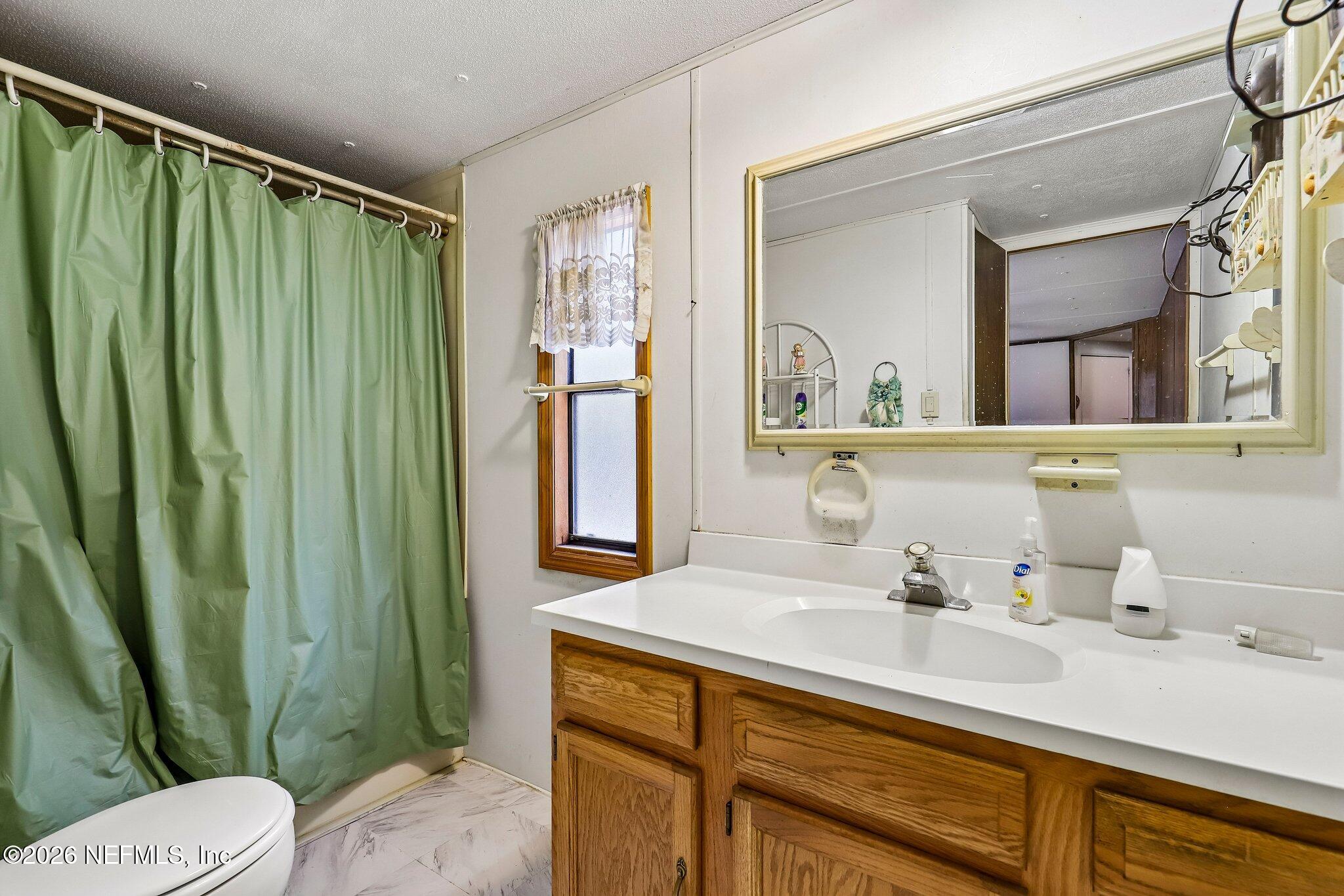 9690 Black Jack Road Macclenny, FL 32063 - Photo 24 of 34 a bathroom with a sink a mirror and a toilet