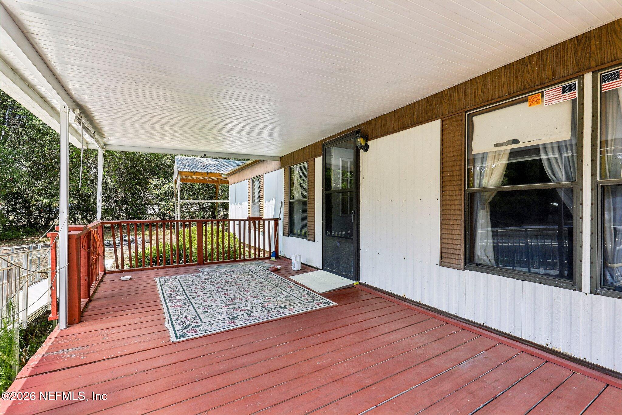 9690 Black Jack Road Macclenny, FL 32063 - Photo 6 of 34 a view of a porch with wooden floor and floor to ceiling window