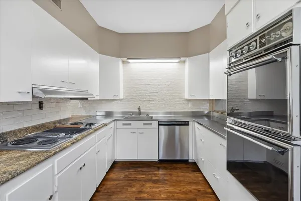 a kitchen with stainless steel appliances a sink stove and cabinets