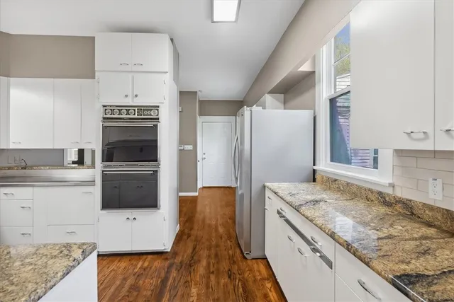 a kitchen with granite countertop a sink stove and refrigerator