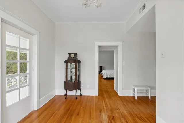 a view of empty room with wooden floor and fan