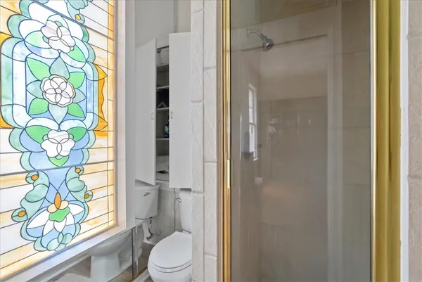 a bathroom with a granite countertop shower a toilet and a shower curtain