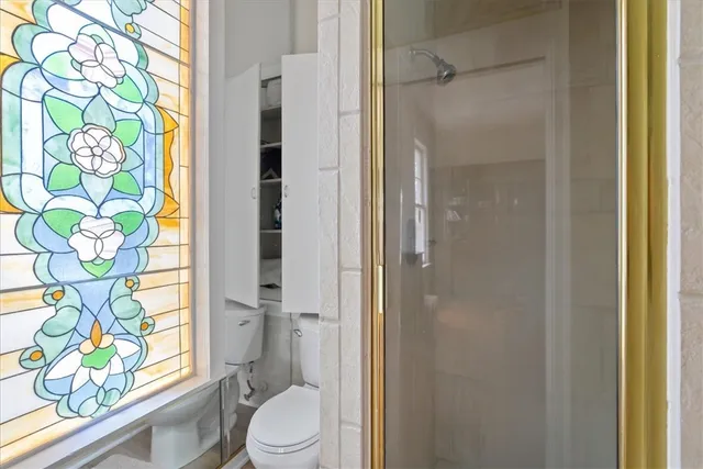 a bathroom with a granite countertop shower a toilet and a shower curtain