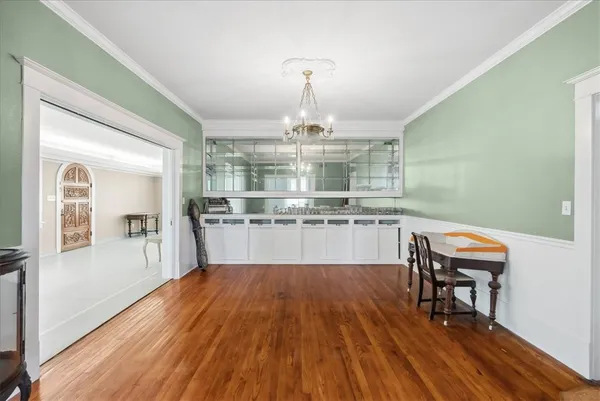 a view of a dining room with furniture a chandelier and wooden floor