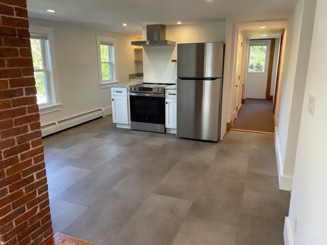 a view of kitchen with refrigerator and microwave