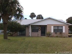 6 Pelican Lane Edgewater, FL 32141 - Photo 1 of 1 a front view of house with yard and trees in the background