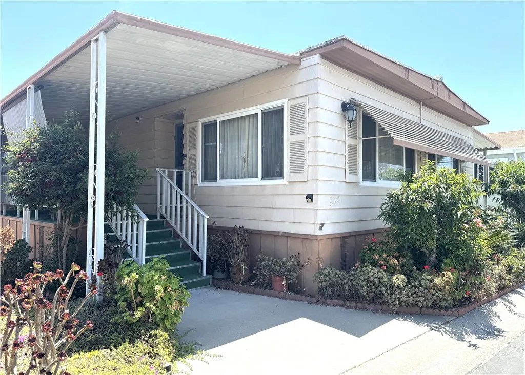 11250 Beach Stanton Ca, Unit 31 Stanton, CA 90680 - Photo 2 of 15 a front view of a house with a garden