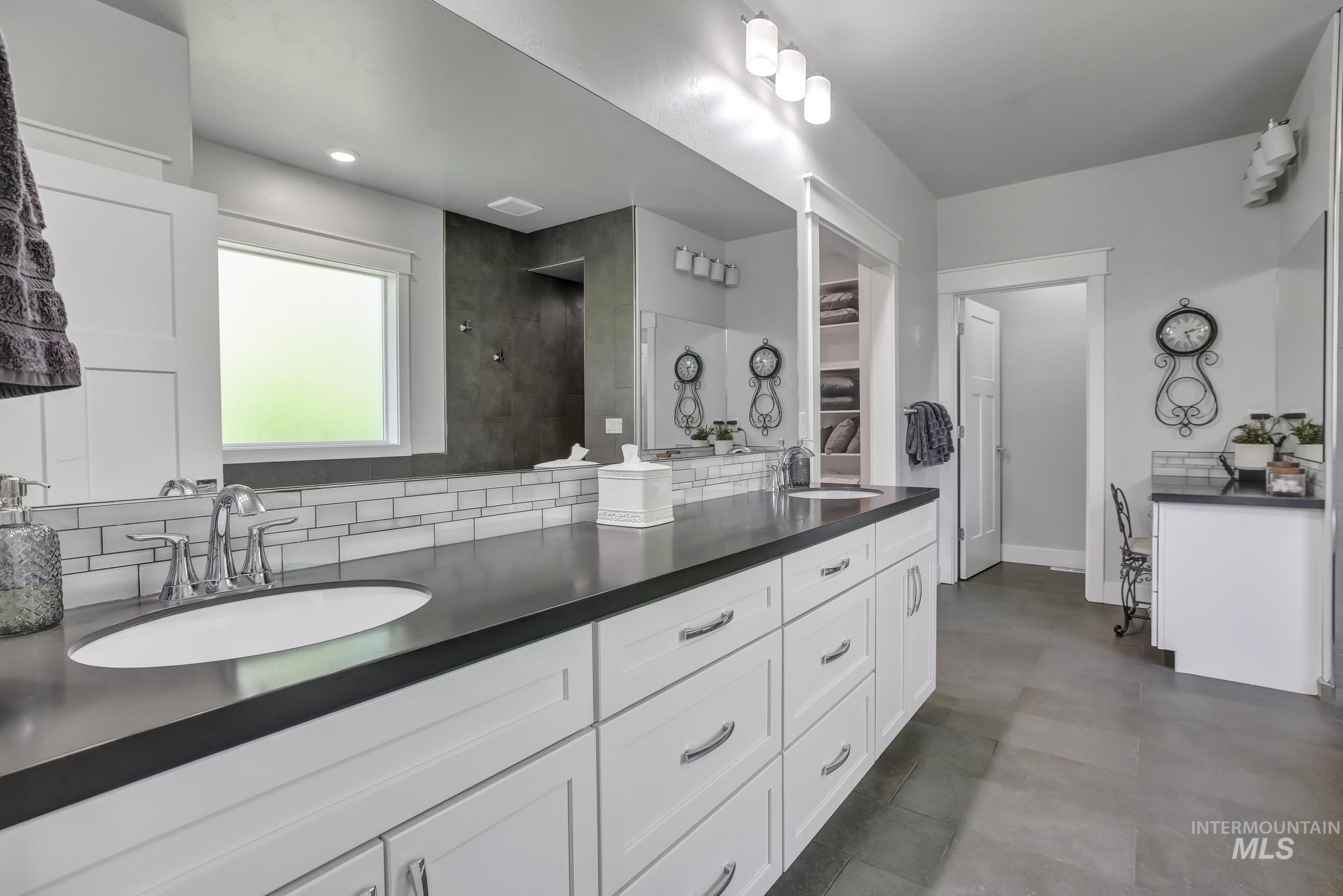1937 Tamarack Loop Twin Falls, ID 83301 - Photo 33 of 50 Spacious bathroom featuring an extended white vanity with multiple cabinets and drawers, dark countertops, and dual undermount sinks