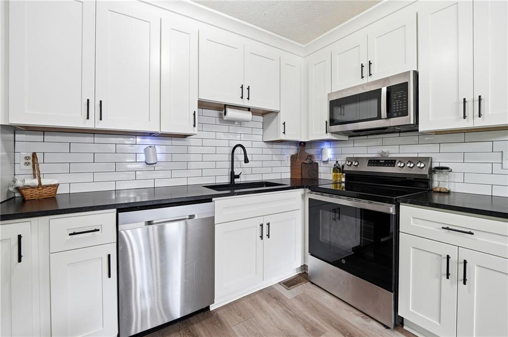 612 Beaver Ridge Road Jasper, GA 30143 - Photo 15 of 38 a kitchen with white cabinets and black appliances
