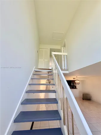 a view of an empty room with wooden floor and windows