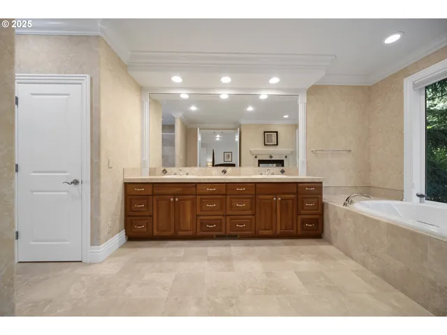 a bathroom with a tub a sink and a mirror