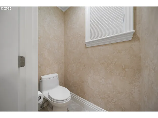 a white toilet sitting next to a white wall