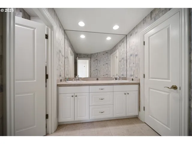a bathroom with a granite countertop sink a large mirror a shower and a bathtub