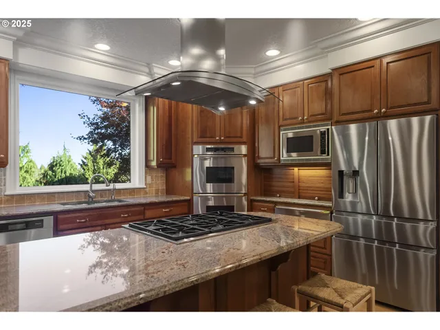 a kitchen with stainless steel appliances granite countertop a stove a sink and a microwave