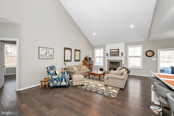 a kitchen with kitchen island granite countertop a dining table chairs and white cabinets