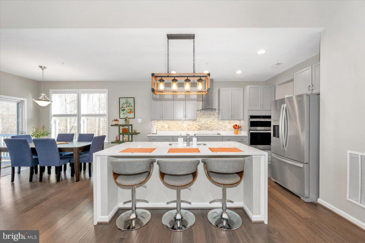 7796 Old Receiver Road Frederick, MD 21702 - Photo 18 of 65 a kitchen with kitchen island granite countertop a dining table chairs and white cabinets
