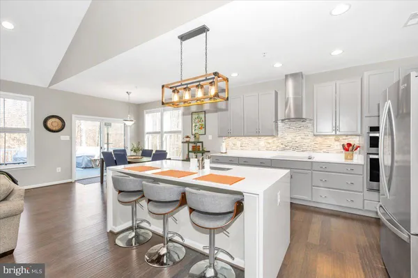 a large white kitchen with lots of counter top space a sink appliances and cabinets