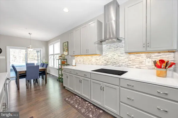 a large kitchen with stainless steel appliances lots of counter space and wooden floor