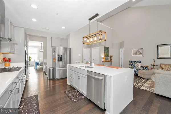 a view of a dining room and livingroom with furniture wooden floor a chandelier