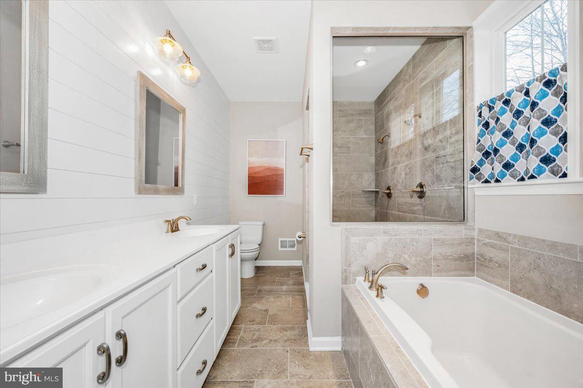 7796 Old Receiver Road Frederick, MD 21702 - Photo 30 of 65 a bathroom with a tub a sink and a large mirror