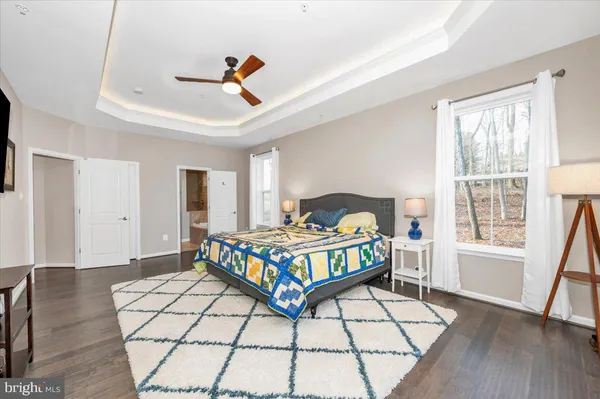 a bedroom with a bed a window and wooden floor