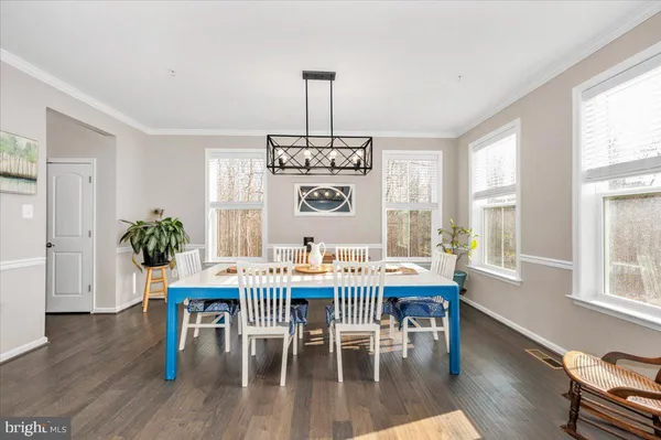 a view of a dining room with furniture wooden floor and chandelier