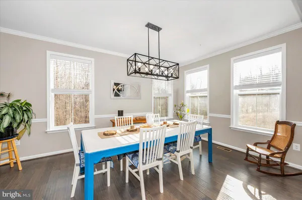 a dining room with furniture window and wooden floor