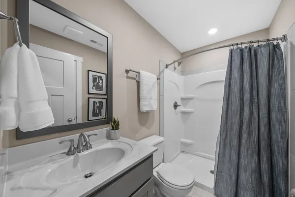 a bathroom with a sink a toilet and shower