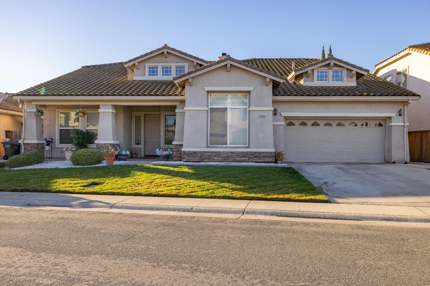 10050 Cameron Pines Way Sacramento, CA 95829 - Photo 2 of 31 a front view of a house with a yard and potted plants
