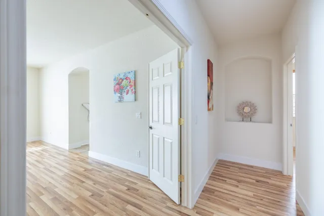 a view of a hallway with wooden floor and closet