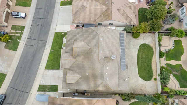 an aerial view of a residential house with pool and plants