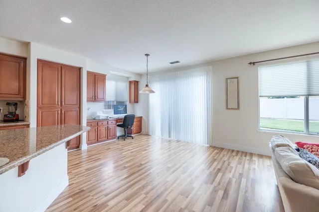 a view of a kitchen with kitchen island wooden floors center island and stainless steel appliances