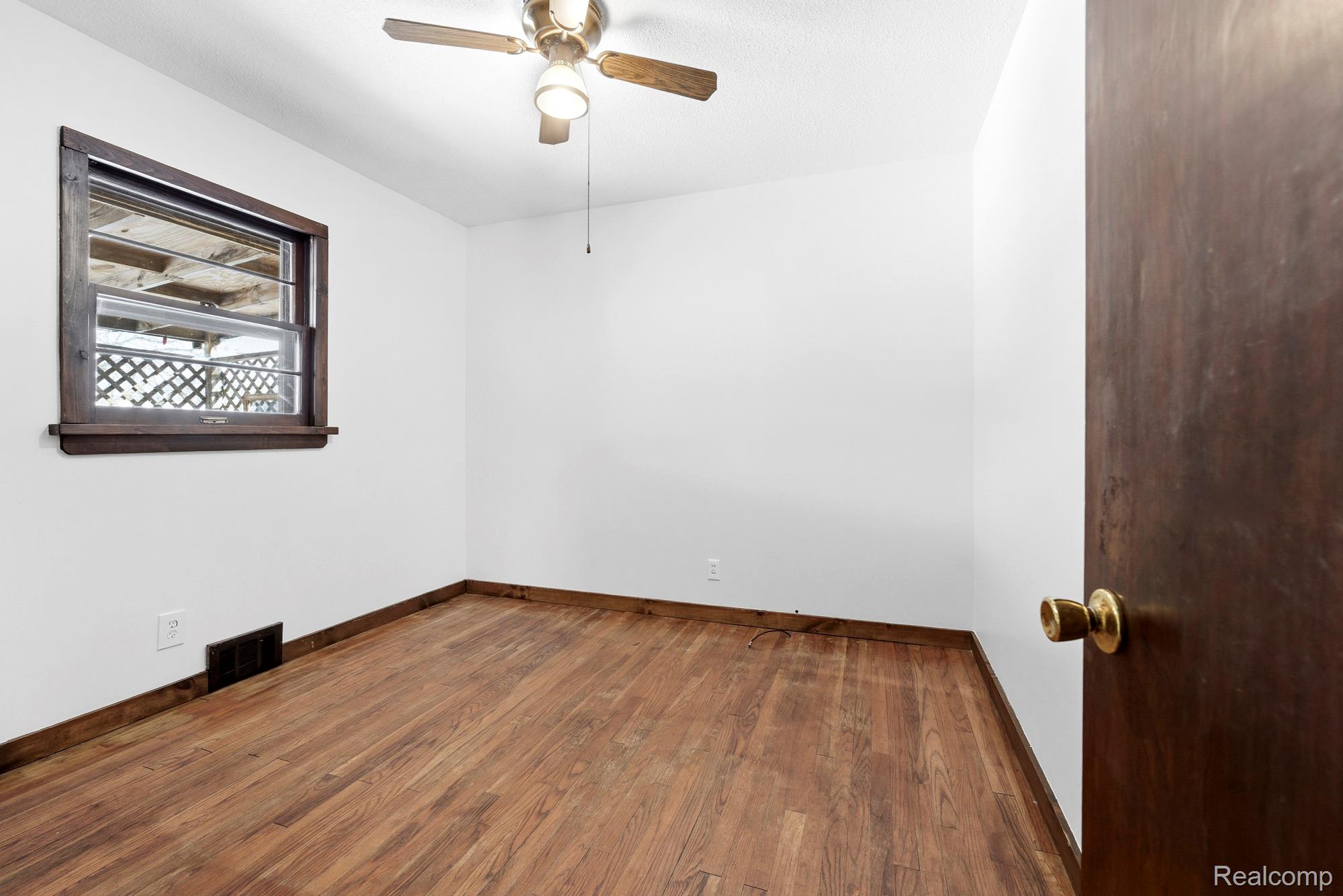 3375 Grant Road Rochester, MI 48309 - Photo 15 of 28 Empty room featuring dark wood finished floors and a ceiling fan