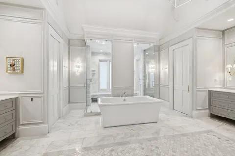 a spacious bathroom with a tub shower and mirror
