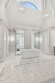 a large white bathroom with a large mirror and shower