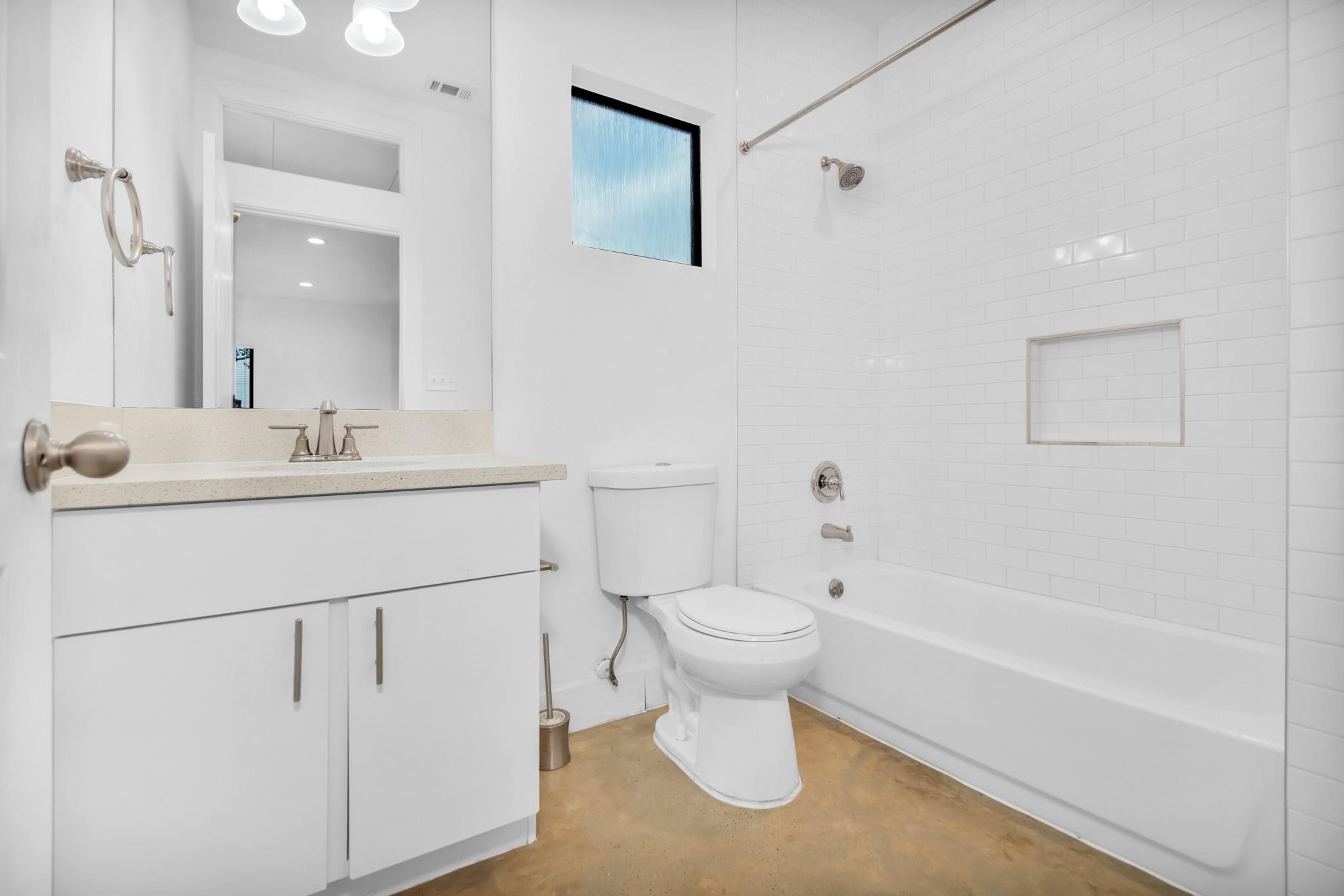 603 Edgewood Street, Unit B Houston, TX 77023 - Photo 9 of 16 Contemporary full bath features a bright white vanity, tiled shower-tub combo, and a privacy window for soft, natural light.