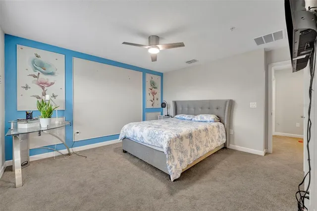 a spacious bedroom with a bed and a cabinets