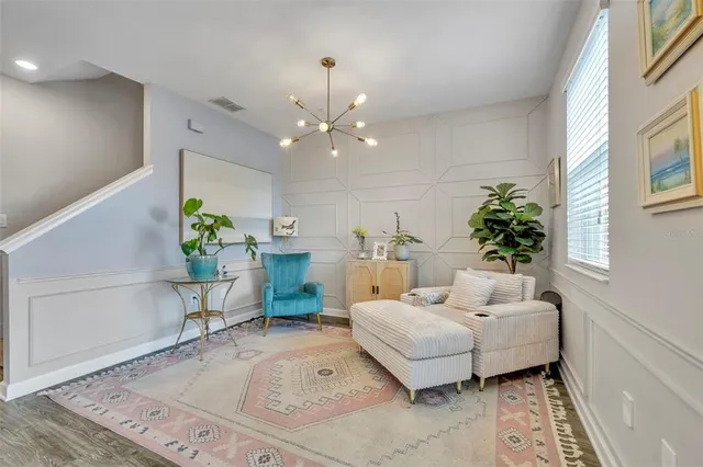 a living room with furniture and a chandelier