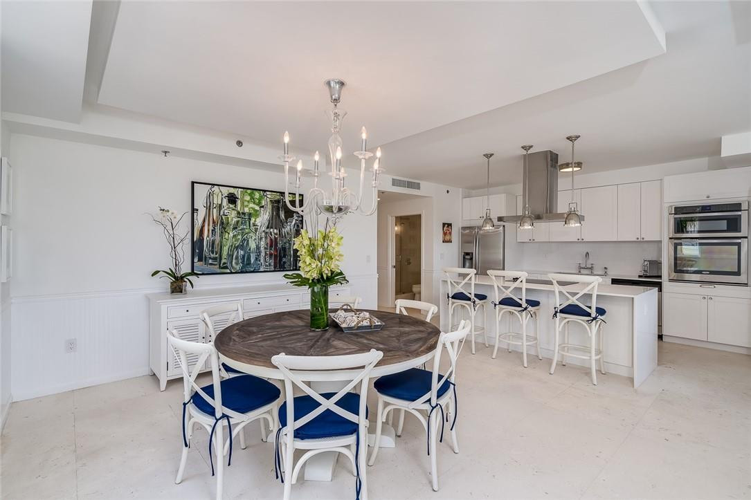 217 Hendricks Isle, Unit 402 Fort Lauderdale, FL 33301 - Photo 7 of 39 a view of a dining room with furniture and chandelier
