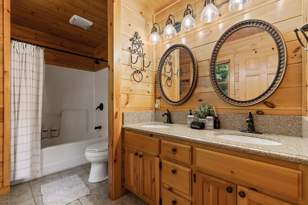 220 Solar Drive Blue Ridge, GA 30513 - Photo 21 of 59 a bathroom with a granite countertop toilet a sink and mirror