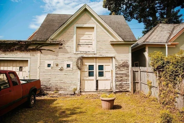 a view of a street with potted plants and large trees